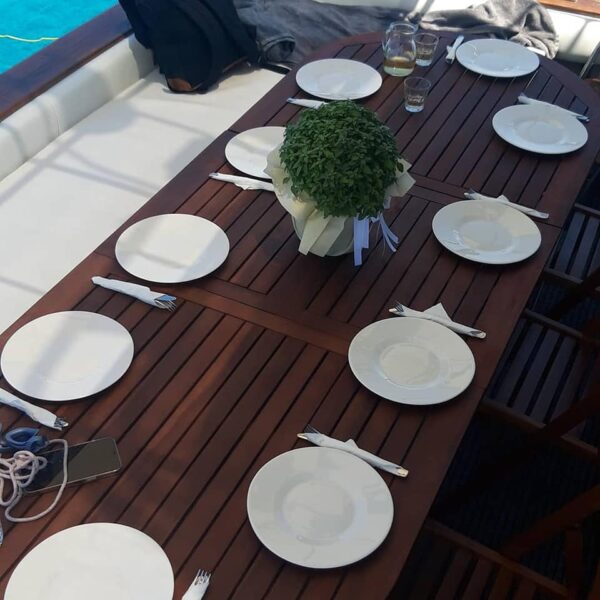 Plates and knives and forks on a wooden table on a yacht