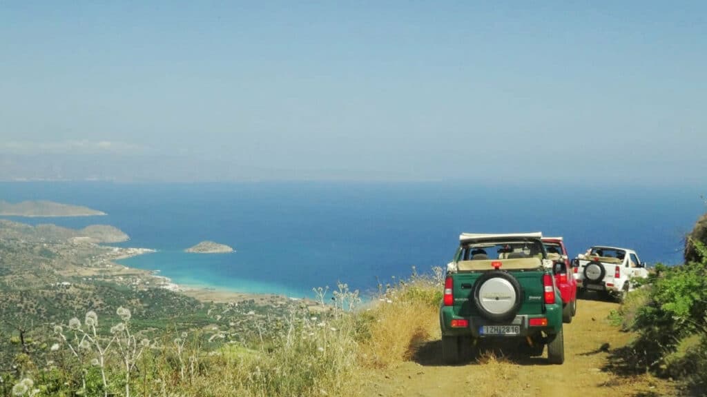 Jeeps on a road in Cretan mountains looking down to the sea