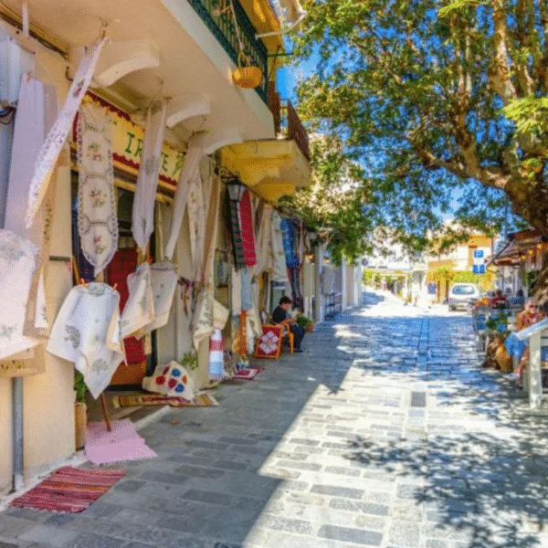 Cretan Villages/a small road in Kritsa village in Crete, with men sitting at tables